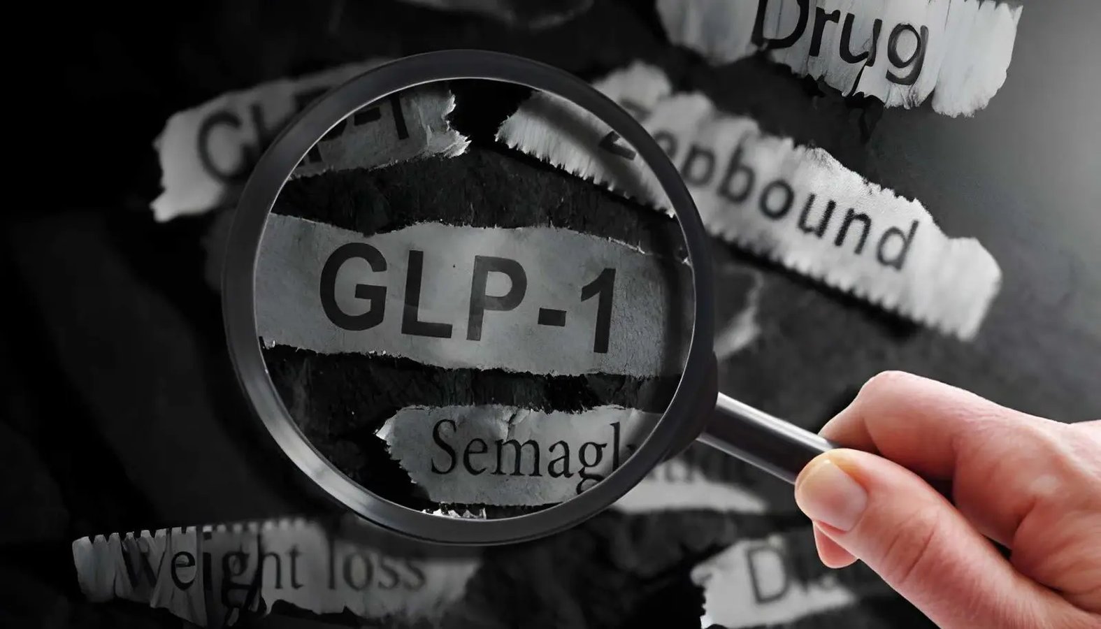 Magnifying glass highlighting the term GLP-1 among printed weight loss and medication terms.