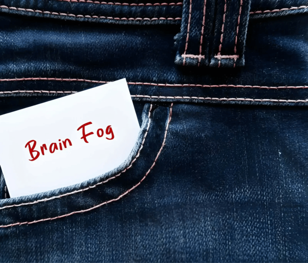 Note reading “Brain Fog” tucked into a denim pocket, illustrating menopause brain fog.