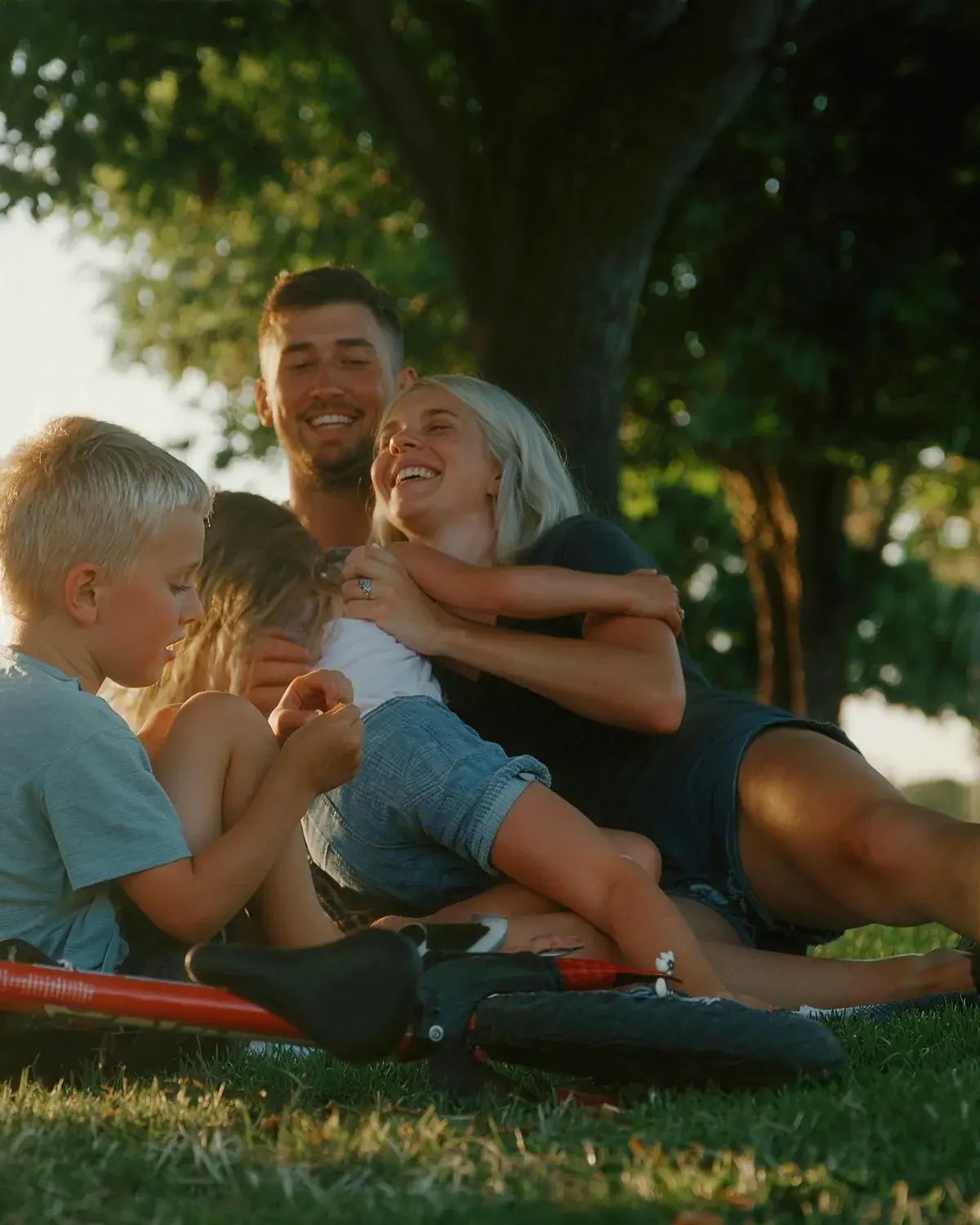 A mother playing with her children on the grass