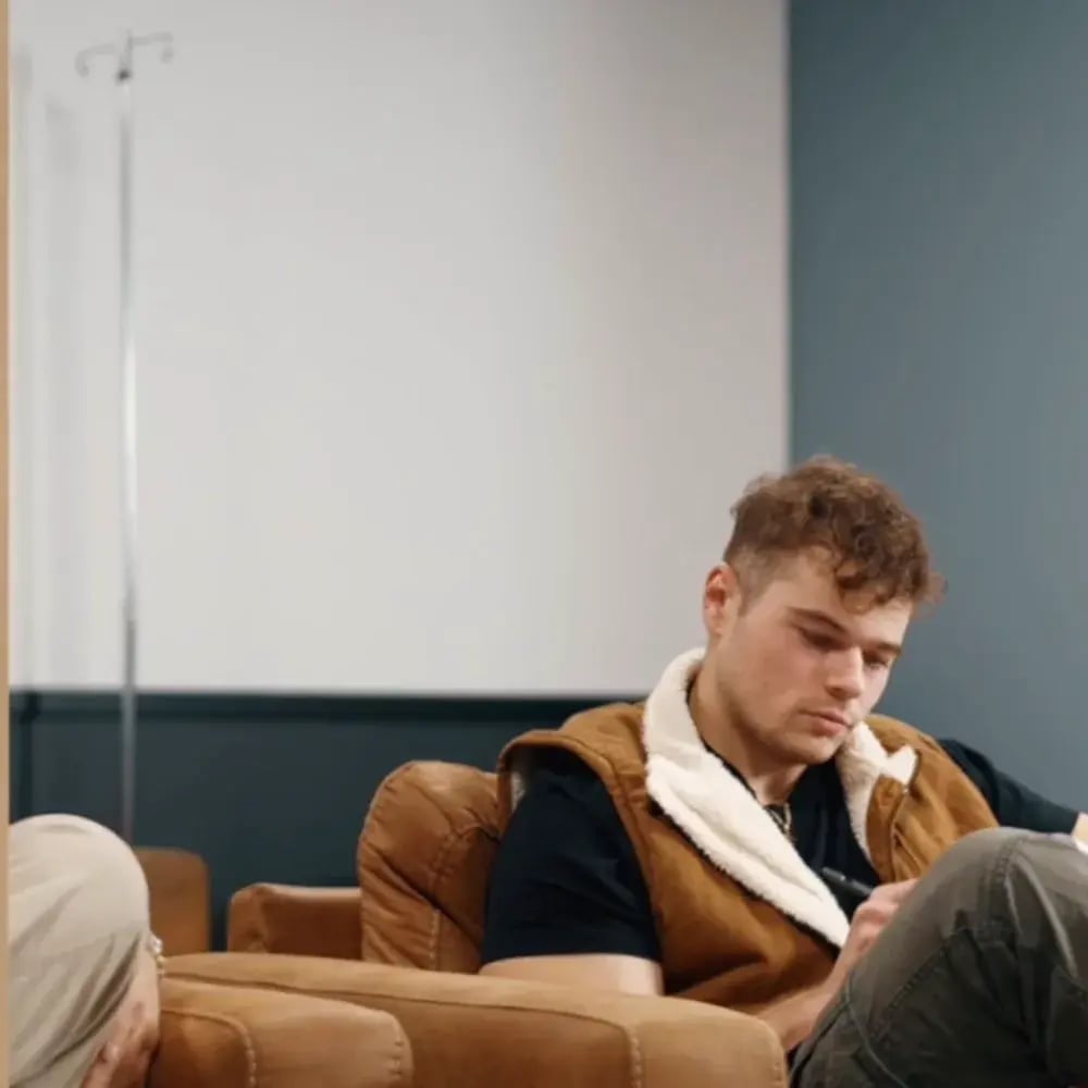 A patient relaxing on the leather couch in the True Test IV lounge