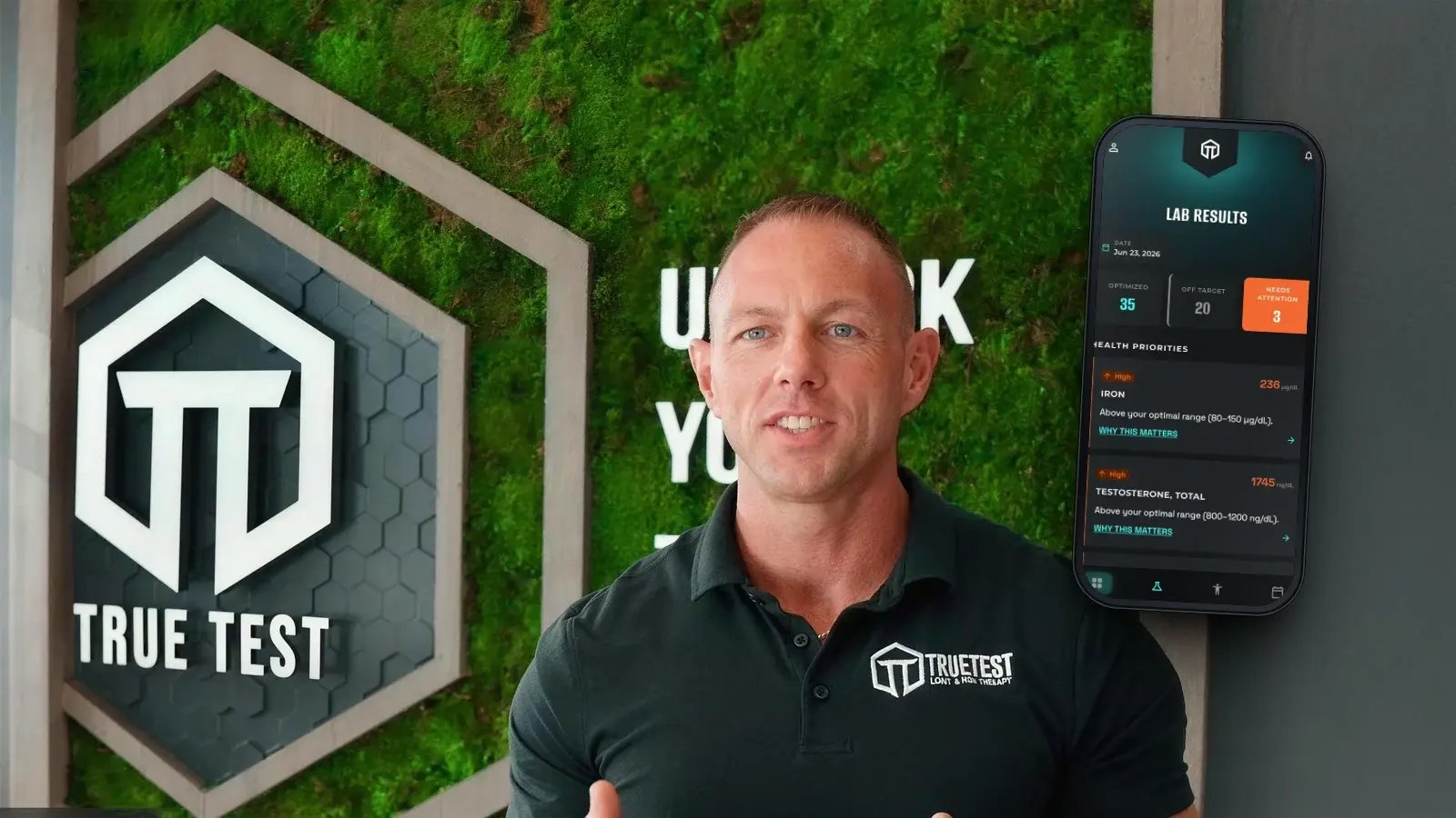 Matt Short, True Test founder, in front of the clinic moss wall with the True Test app showing lab results scored optimized, off target or needs attention